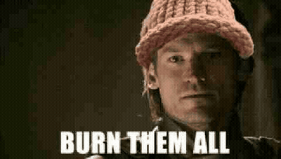 A Man Wearing A Pink Knitted Hat Is Holding A Gun And Saying `` Burn Them All '' . GIF