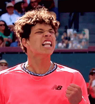 A Man Wearing A Pink New Balance Shirt Is Celebrating GIF
