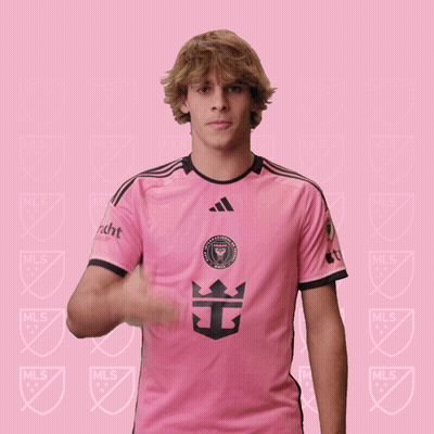 A Man Wearing A Pink Shirt With A Crown On The Front GIF
