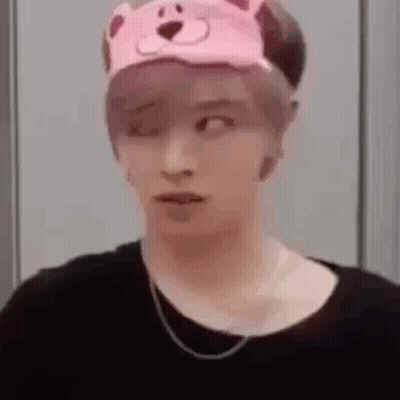 A Man Wearing A Pink Teddy Bear Hat And A Black Shirt . GIF