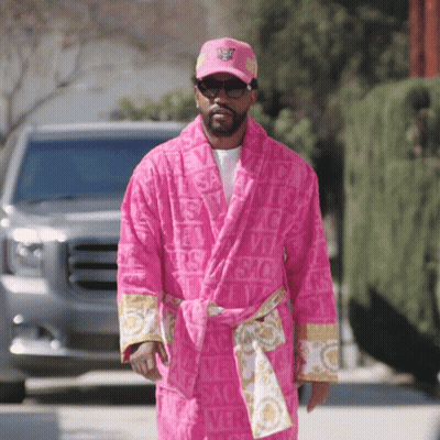 A Man Wearing A Pink Versace Robe And A Pink Hat GIF