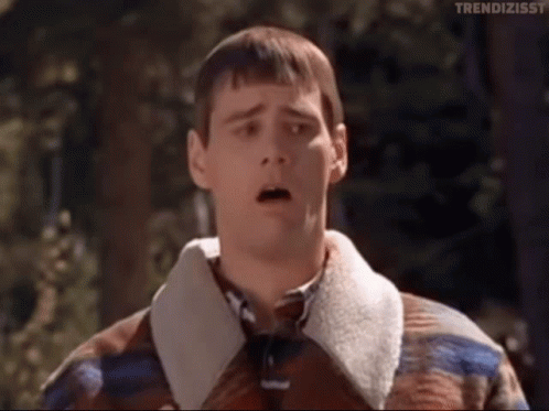 A Man Wearing A Plaid Jacket And Tie Is Making A Surprised Face . GIF