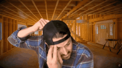 A Man Wearing A Plaid Shirt And A Black Hat Is In A Room Under Construction GIF