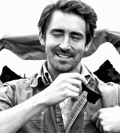A Man Wearing A Plaid Shirt And A Denim Jacket Is Smiling With His Eyes Closed GIF