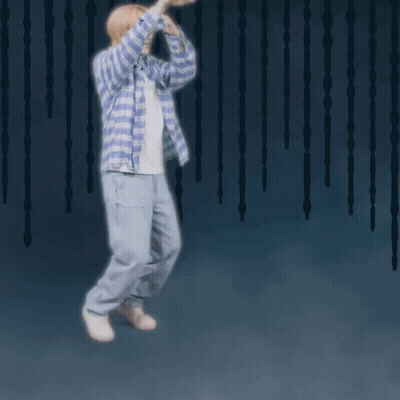 A Man Wearing A Plaid Shirt And Jeans Is Jumping In The Air GIF