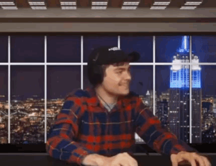 A Man Wearing A Plaid Shirt Is Giving The Middle Finger GIF