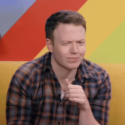 A Man Wearing A Plaid Shirt Is Making A Face GIF
