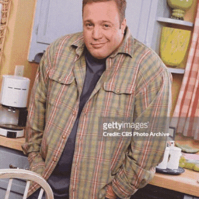 A Man Wearing A Plaid Shirt Is Standing In A Kitchen GIF