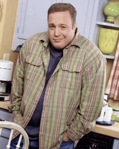 A Man Wearing A Plaid Shirt Is Standing In A Kitchen GIF