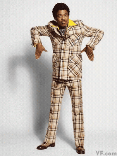 A Man Wearing A Plaid Suit Is Standing With His Hands On His Hips GIF