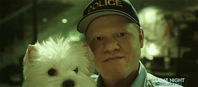 A Man Wearing A Police Hat Holds A White Dog GIF