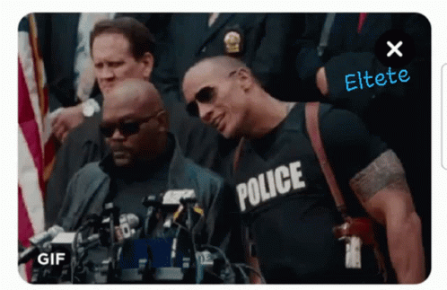 A Man Wearing A Police Shirt Is Standing In Front Of A Crowd GIF