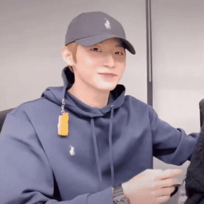 A Man Wearing A Polo Hat And A Blue Hoodie Is Smiling GIF