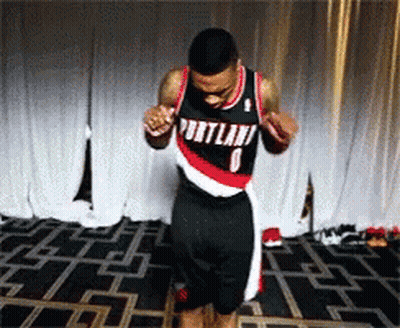 A Man Wearing A Portland Jersey Is Dancing On A Stage GIF