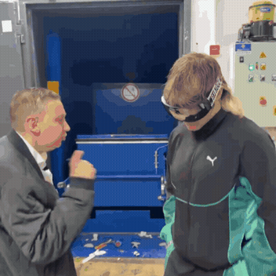 A Man Wearing A Puma Jacket Talks To A Man Wearing Goggles GIF