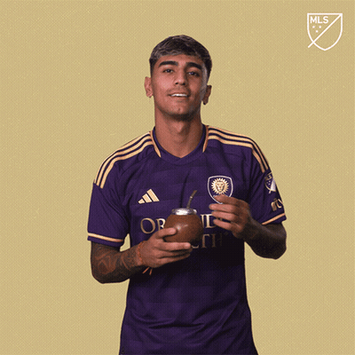 A Man Wearing A Purple Adidas Shirt Is Holding A Soccer Ball GIF