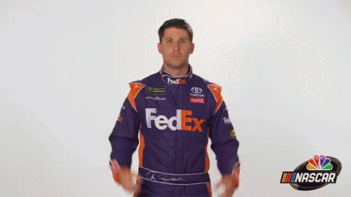 A Man Wearing A Purple And Orange Fedex Racing Suit GIF