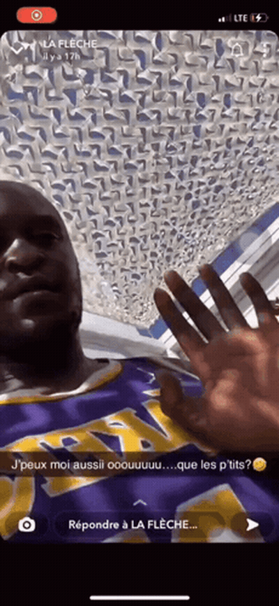 A Man Wearing A Purple And Yellow Lakers Jersey Is Waving His Hand GIF