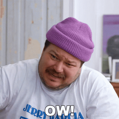 A Man Wearing A Purple Beanie And A White Shirt That Says Jerry GIF