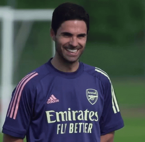 A Man Wearing A Purple Emirates Fly Better Jersey Smiles GIF