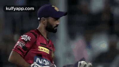 A Man Wearing A Purple Hat And A Red Shirt With A Noki Logo On It . GIF