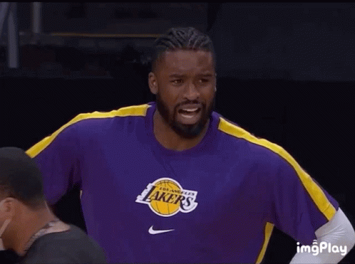 A Man Wearing A Purple Lakers Shirt Smiles GIF