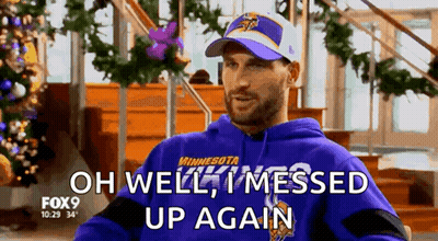 A Man Wearing A Purple Minnesota Vikings Sweatshirt Is Sitting In Front Of A Christmas Tree . GIF