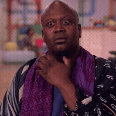 A Man Wearing A Purple Scarf Around His Neck Looks Surprised GIF