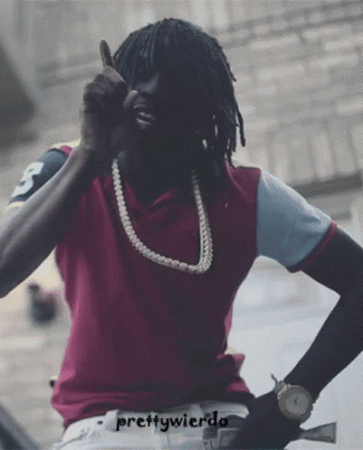 A Man Wearing A Purple Shirt And A Pearl Necklace Is Giving A Thumbs Up Sign GIF
