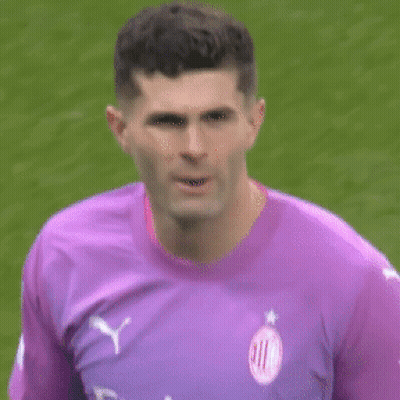 A Man Wearing A Purple Shirt That Says Fly Emirates Looks At The Camera GIF