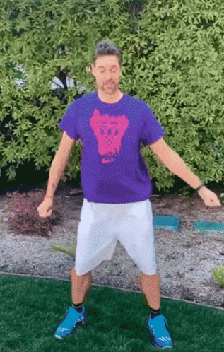 A Man Wearing A Purple Shirt With A Skull On The Front GIF