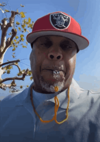 A Man Wearing A Raiders Hat And A Whistle GIF