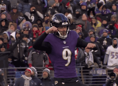 A Man Wearing A Ravens Jersey Is Kicking A Ball GIF
