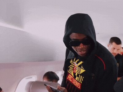 A Man Wearing A Rc Lens Shirt Looks At His Cell Phone GIF