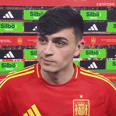 A Man Wearing A Red Adidas Shirt Stands In Front Of A Sign That Says Silbo Telecom GIF