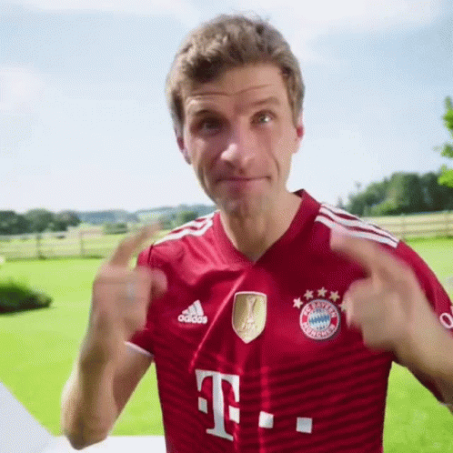 A Man Wearing A Red Adidas Shirt With A T On The Front GIF