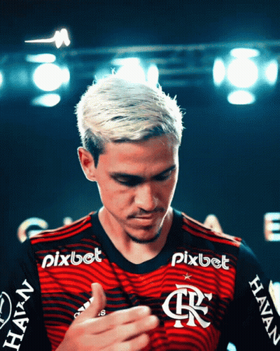 A Man Wearing A Red And Black Shirt With Pixbet Written On The Sleeves GIF