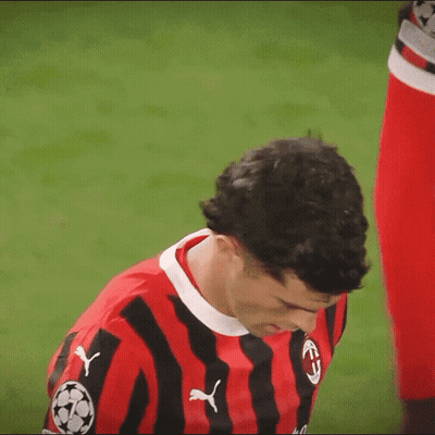 A Man Wearing A Red And Black Striped Shirt With Pumas On The Front GIF