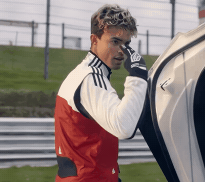 A Man Wearing A Red And White Adidas Jacket Holds His Nose GIF