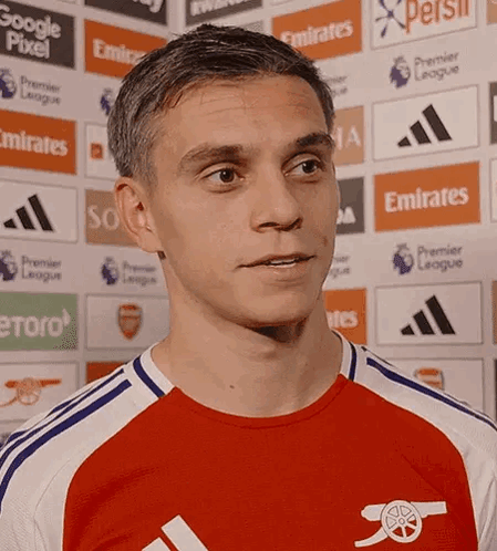 A Man Wearing A Red And White Jersey With An Arsenal Logo GIF