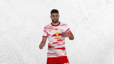 A Man Wearing A Red And White Shirt With A Red Bull On It GIF