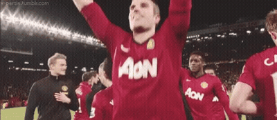 A Man Wearing A Red Aon Jersey Holds His Arms Up GIF