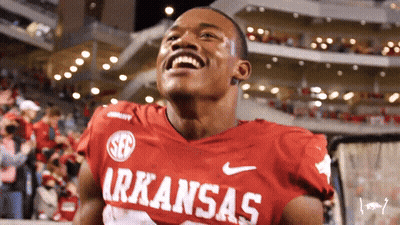 A Man Wearing A Red Arkansas Jersey Is Laughing GIF
