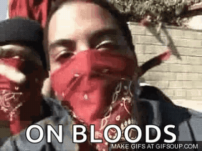 A Man Wearing A Red Bandana On His Face Is Standing Next To Another Man . GIF
