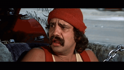 A Man Wearing A Red Beanie And A Red Tank Top With Chains Around His Neck GIF