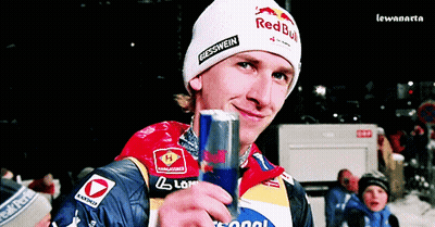 A Man Wearing A Red Bull Hat Is Holding A Can GIF