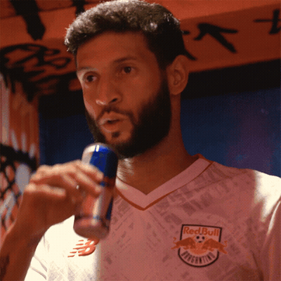 A Man Wearing A Red Bull Jersey Drinks From A Can GIF