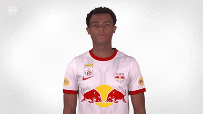 A Man Wearing A Red Bull Jersey Holds His Hands Up GIF