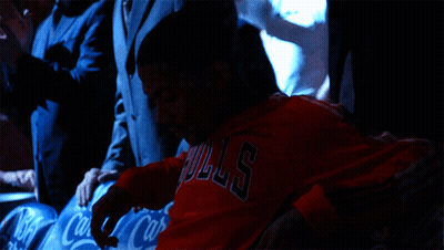 A Man Wearing A Red Bulls Shirt Sits In A Row Of Coca Cola Seats GIF