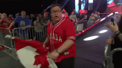A Man Wearing A Red Canada Jersey Is Holding A Canadian Flag GIF